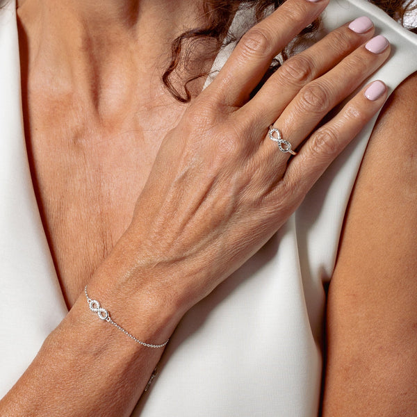 Sterling silver Infinite Hope Statement Ring showcases a pavé zirconia ichthys nestled within the infinity symbol by Rizen Jewelry modeled on a woman