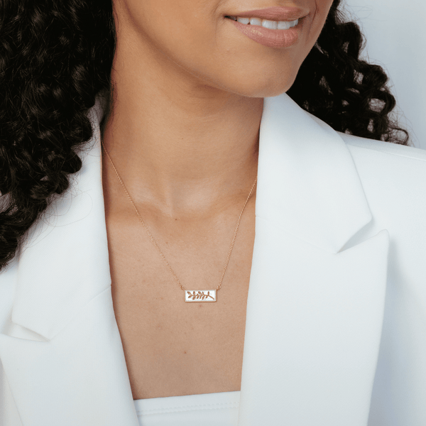 Christian woman wearing 18k gold vermeil Olive Branch necklace from the Rooted Collection by Rizen Jewelry. 